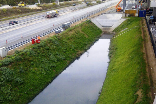 Regenrückhaltebecken mit begrünten Seiten an Schnellstraße