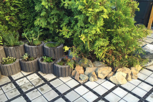 Pflanzkübel und Büsche neben ECORASTER Bloxx Gartenfläche