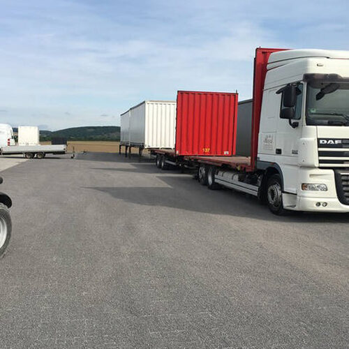 Logistikfläche mit parkenden LKWs auf ECORASTER Bodengittern
