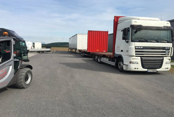 Logistikfläche mit parkenden LKWs auf ECORASTER Bodengittern