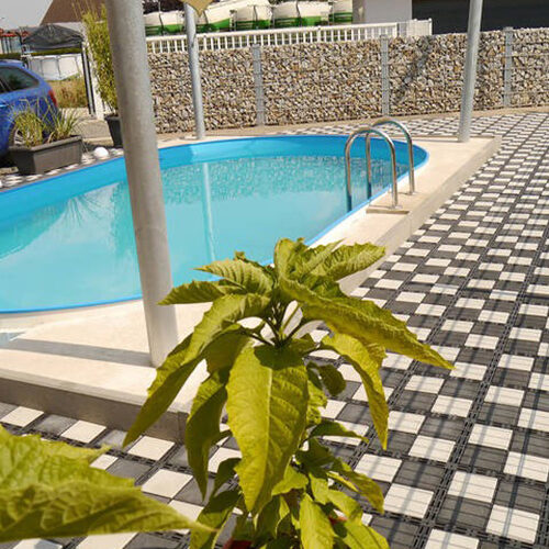 Poolbereich mit Planzen und mit ECORASTER Bloxx Fläche in Schachbrettmuster