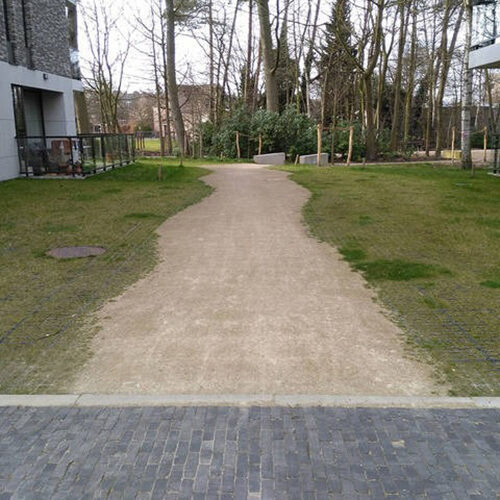 ECORASTER Weg in belgischer Wohnanlage mit Bäumen und Park