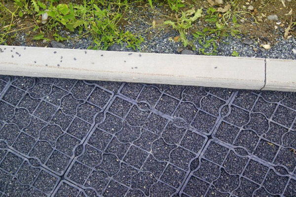 Sicht von oben auf ECORASTER mit Splitt verfüllt, die an eine Randeinfassung grenzen