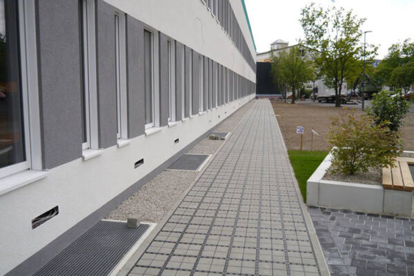 Zufahrt_Selb_01_800x500px ECORASTER Bloxx Weg entlang eines Firmengebäudes