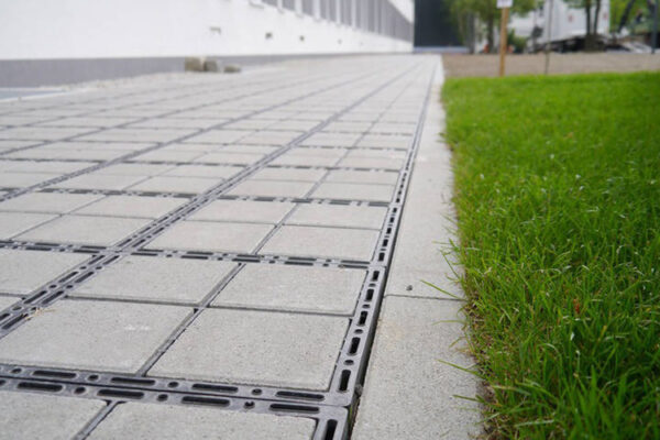 Zufahrt_Selb_04_800x500px Nahaufnahme einer ECORASTER Bloxx Fläche die an einen Randstein einer Grünfläche grenzt